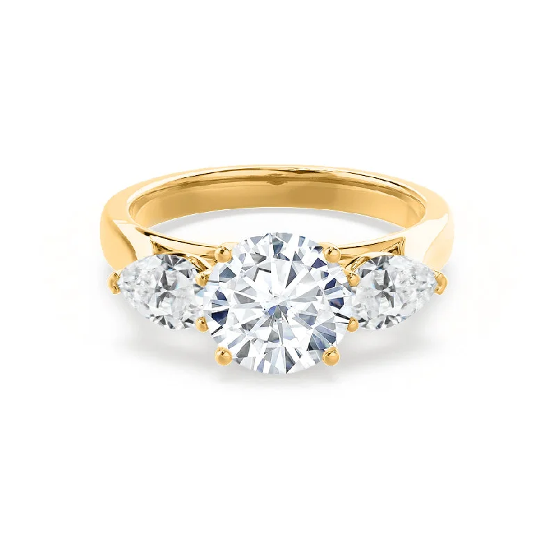 Solitaire diamond engagement ring with a platinum setting for a classic and elegant lookBLOSSOM - Round Moissanite & Pear Cut Diamond 18k Yellow Gold Trilogy