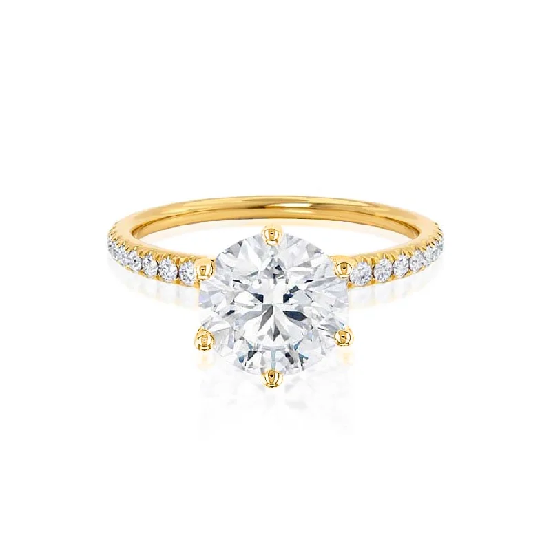 Solitaire diamond engagement ring with a platinum setting for a classic and elegant lookLILLIE LUXE - Round Moissanite & Diamond 18k Yellow Gold Shoulder Set Ring